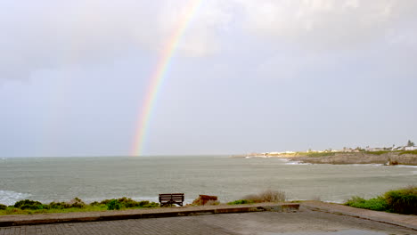 rainbow over ocean in hermanus on day with stormy weather, cape whale coast