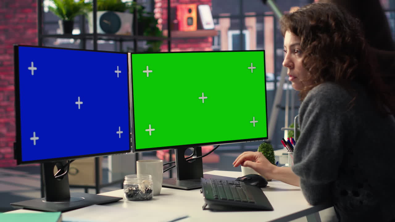 Employee in office working on PC with isolated copy space on dual monitors