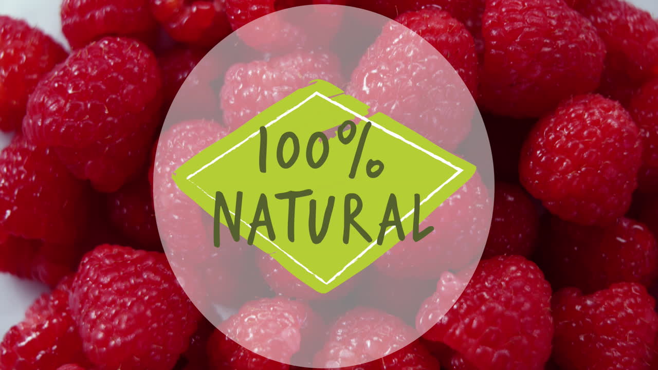 Animation of 100 percent natural text over fresh raspberries in background