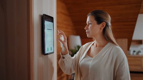 woman interacts with smart home control panel