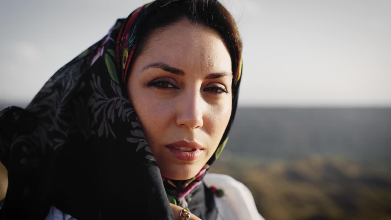 Beautiful middle eastern woman in a traditional headscarf looking at camera