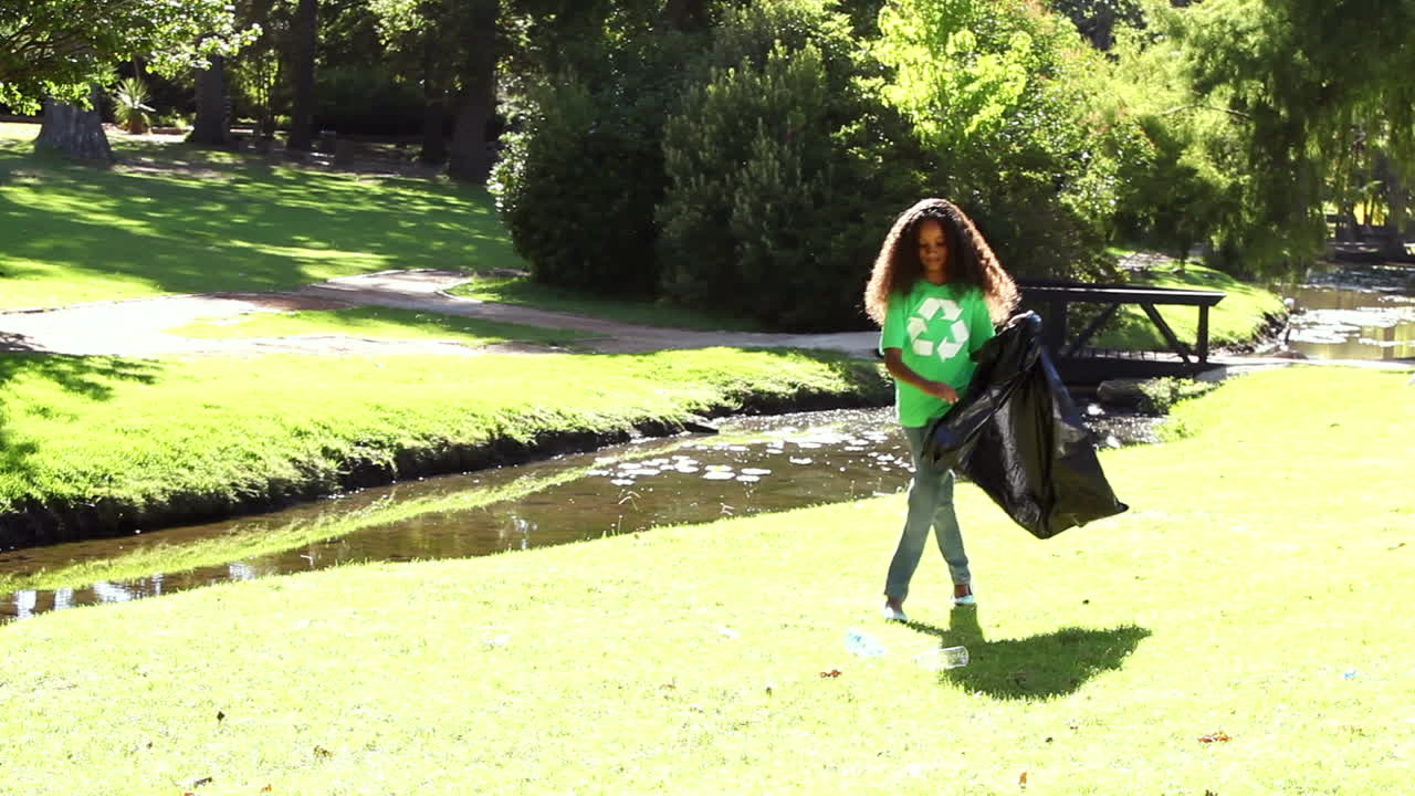 una joven recogiendo la basura en el parque