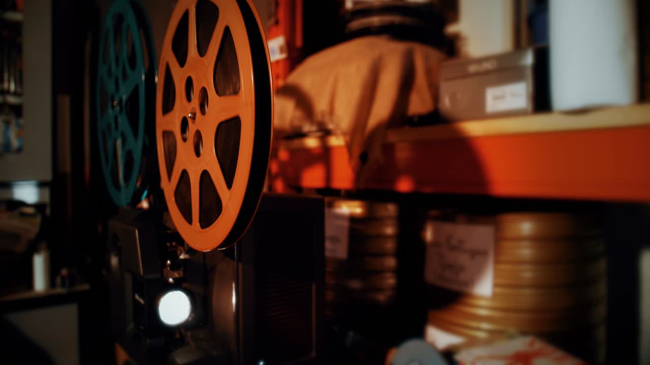 Proiettore cinematografico vintage che riproduce un film con bobine in rotazione.