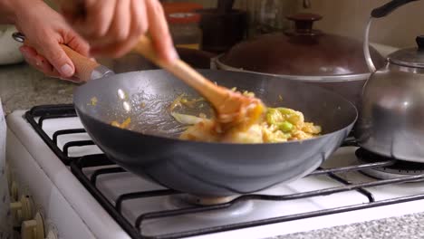 cooking mixed vegetables in a wok with napa cabbage