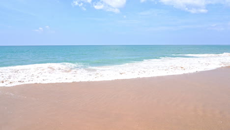 slow motion, tropical sea waves breaking on sandy beach on hot summer day