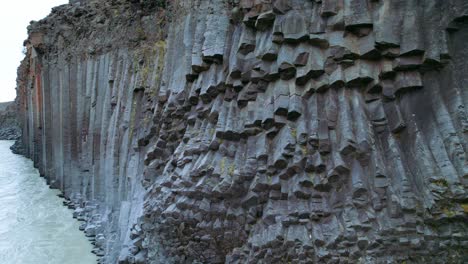 Aerial:-Crane-shot-close-up-details-of-Studlagil-River-Canyon-with-basalt-columns-in-Northeast-Iceland