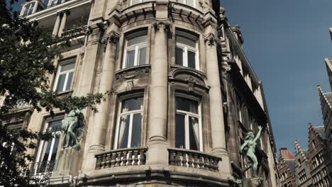 historic antwerp city architecture with intricate statues and detailed stone facades basking in sunlight against a crisp blue sky