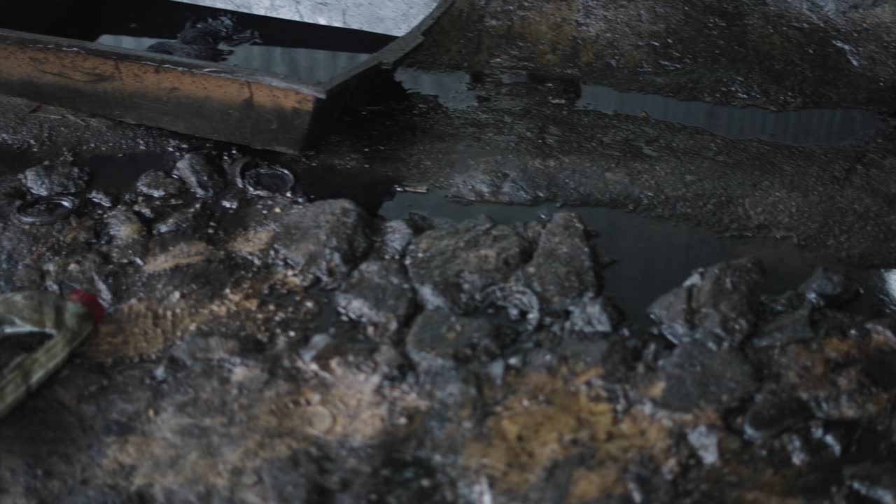 Dirty Garage with Oil Leaks and Discarded Parts