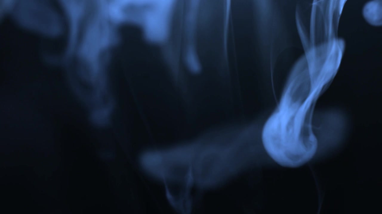 Nuvola di fumo blu su sfondo scuro.