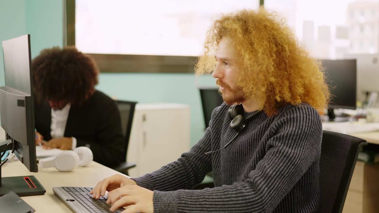 Modern man smiling while working in coworking space