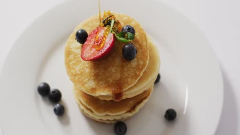 video of pancakes on plate seen from above on white background