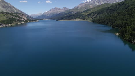 aerial view over calm lake silvaplana on clear sunny day