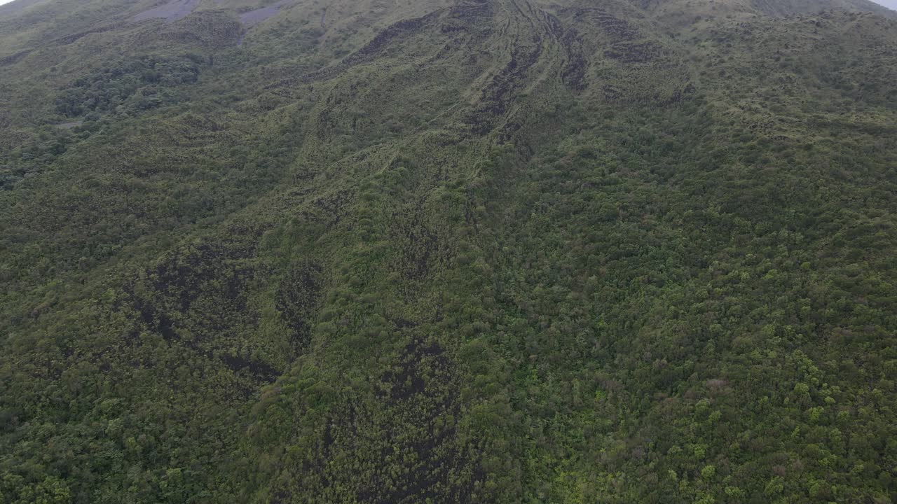 vista aérea que se inclina hacia arriba, vista panorámica del paisaje del volcán arena en costa rica, cielo azul brillante en el fondo
