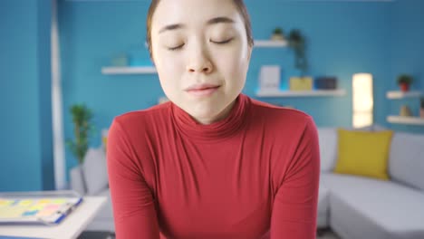 아시아 여성이 사려 깊게 주위를 둘러보고 카메라를 쳐다보고 있습니다.
