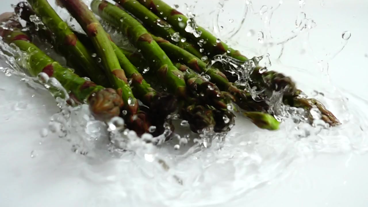 Asparagi verdi freschi. Schizzi d'acqua. Al rallentatore
