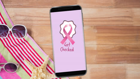 Animation-of-pink-breast-cancer-ribbon-logo-with-breast-cancer-text-on-smartphone-screen