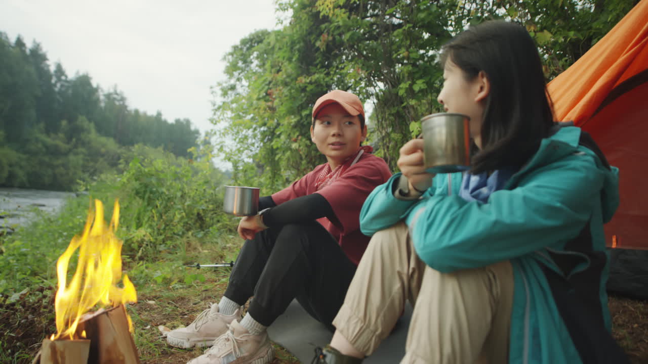 Asian Female Tourists Talking by Campfire