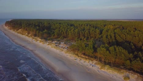 hermosa vista aérea de la costa del mar báltico en una tarde soleada, puesta de sol, hora dorada, playa con arena blanca, erosión costera, cambios climáticos, tiro de drones de gran angular avanzando