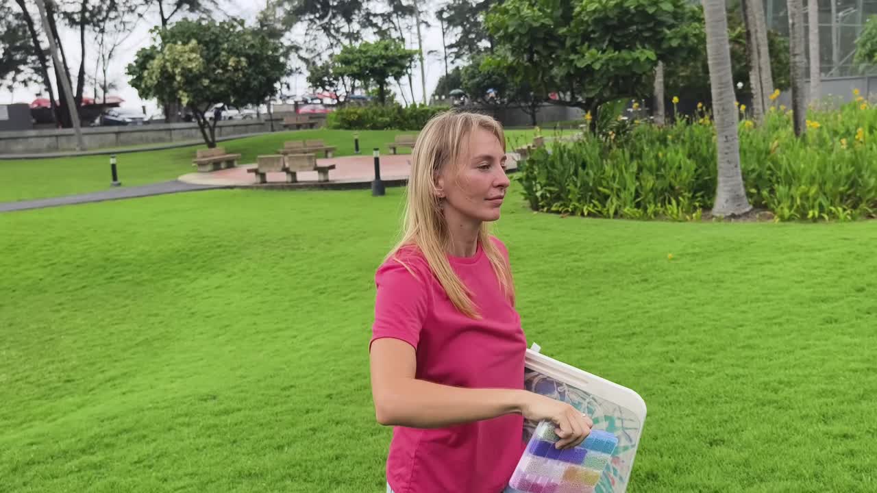 mujer llevando una mesa colorida en un parque