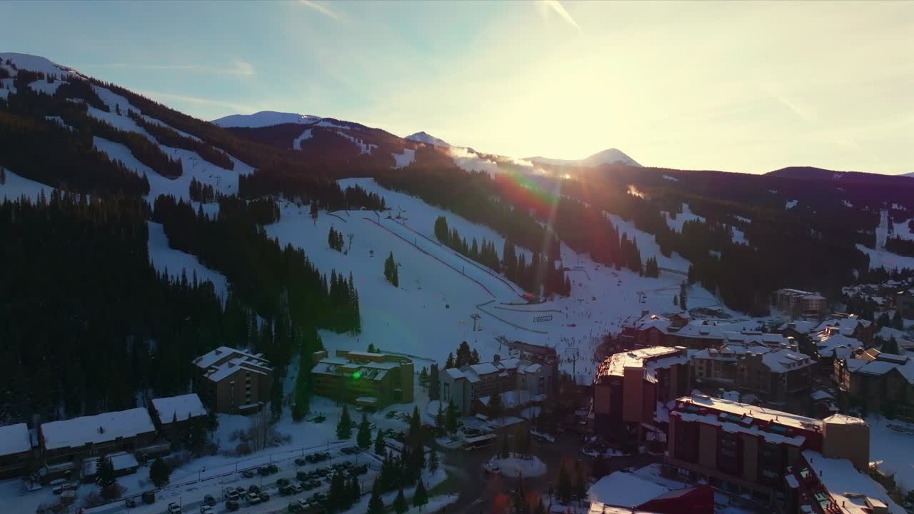Copper Mountain Ski Resort Winter Solstice December sun flares sunset aerial drone Colorado fresh snow American Flyer Eagle lodge hotel chairlift gondola halfpipe snowboarders trails forward pan up