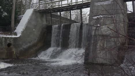 Natural-flowing-river-waterfall-dam-snow-ice-Alton-Mill-Caledon-Ontario-Canada-landscape-environment-conservation-riverbed-catchment-North-America