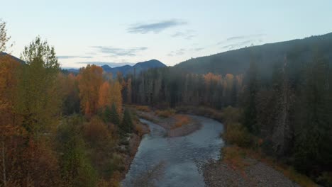 Morning-Journey-Along-a-Foggy-River-Winding-Through-a-Colorful-Forest-in-Autumn