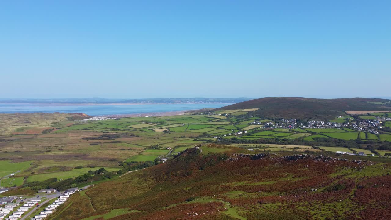 Aerial View Over Caravan Camping Holiday Park with Llangenith Village with Loughor Estuary with Pembrey in Distance Background with Natural Moorland with Paths in Foreground in Wales UK 4K