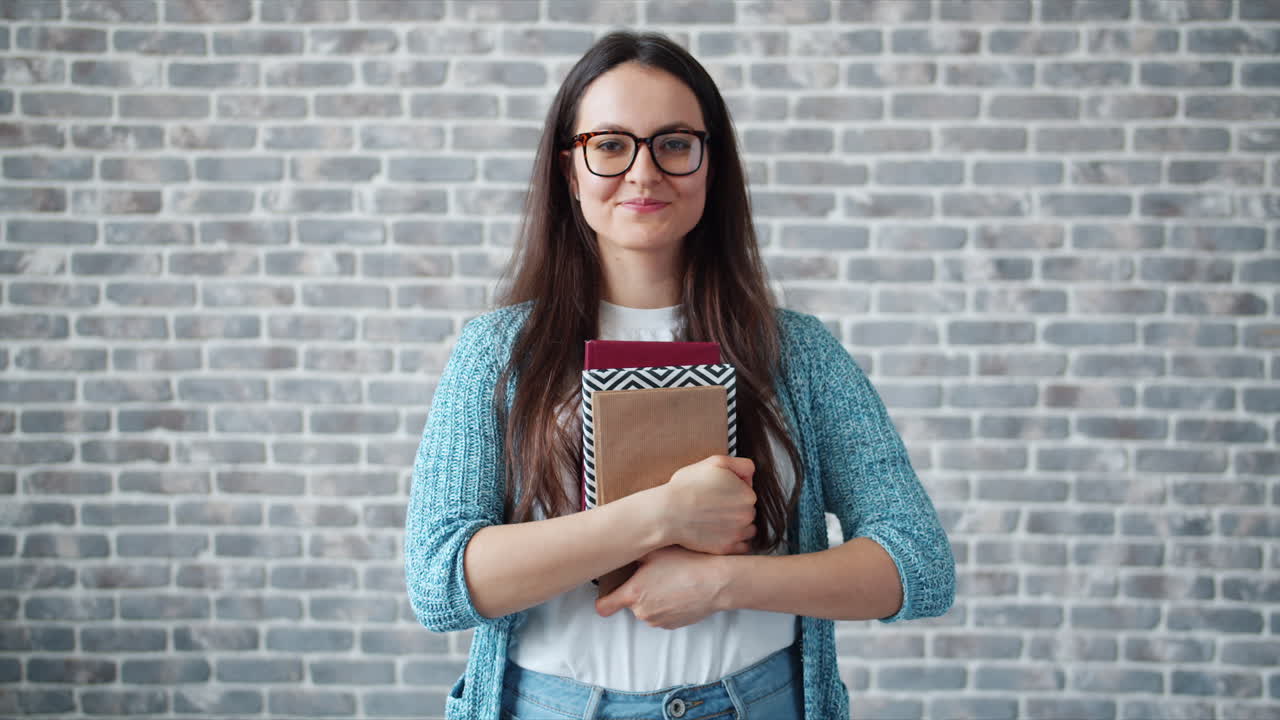 Woman holding books, smiling
