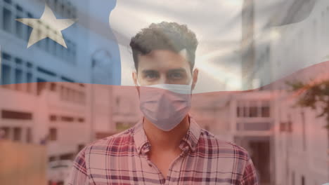 animation of flag of chile waving over latin man wearing face mask in city street