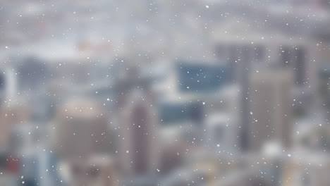 snow particles falling over blurred view of cityscape in background