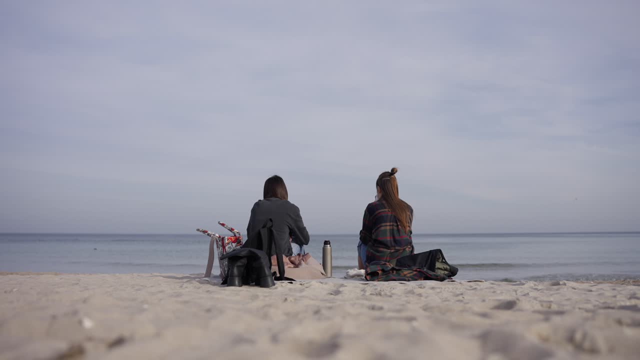 Two women relaxing on a sandy beach