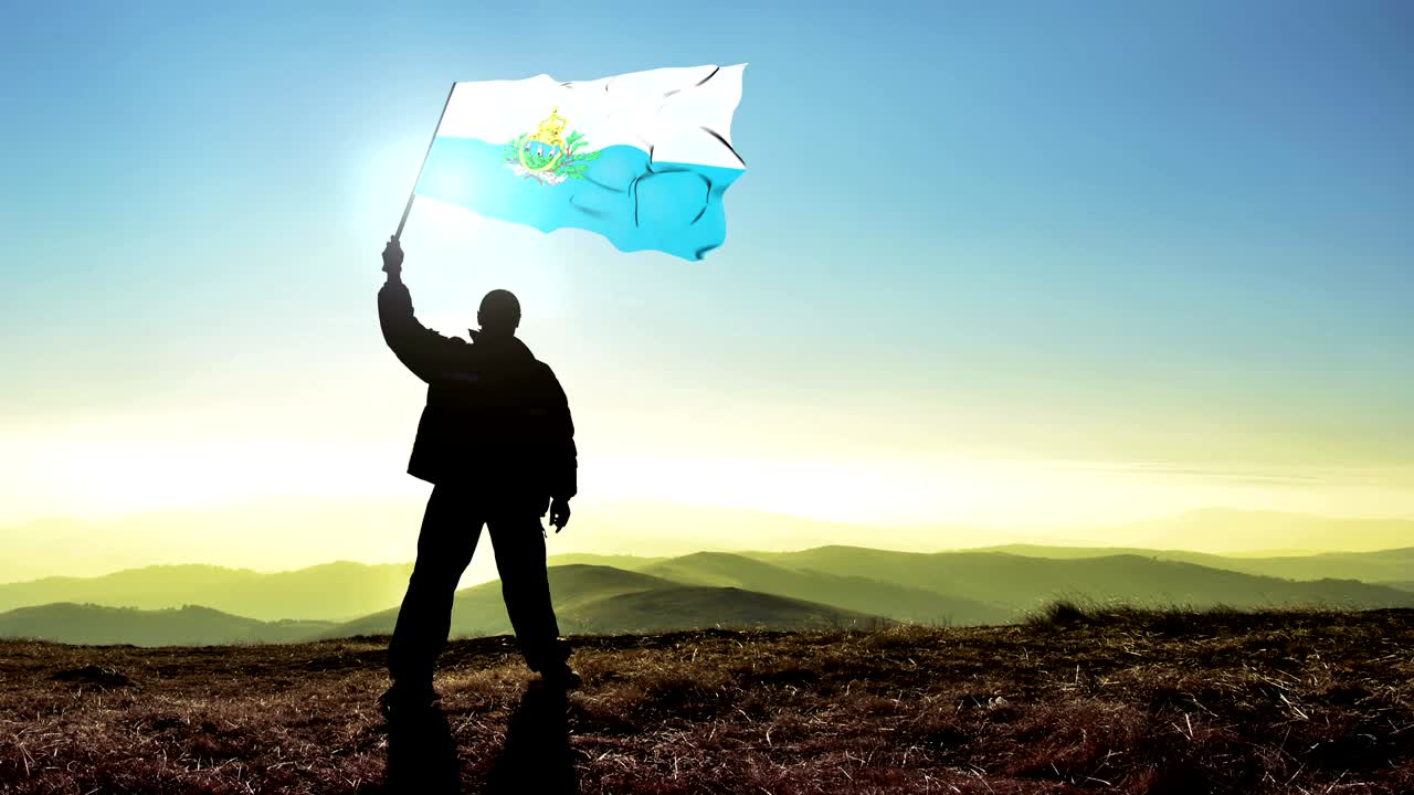 산꼭대기 위에서 산마리노 발을 흔들고 있는 성공적인 실루 남자 우승자, 시네마그라프 루프 배경