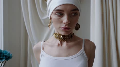 woman in elegant gold jewelry and white turban