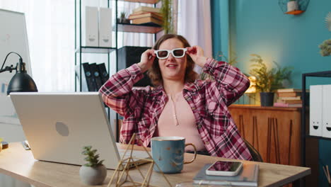 Business-woman-freelancer-taking-break-from-work-wearing-3D-glasses-eating-popcorn-watching-movie