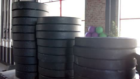 stacked black weight plates resting near window