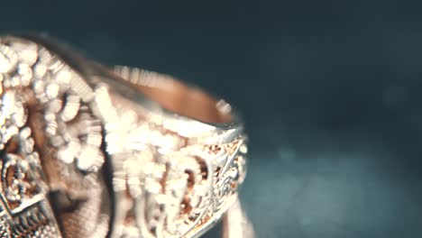 una foto macro detallada de un anillo masónico de textura dorada, en un soporte giratorio, reflejo de espejo, símbolo de illuminati, luz de estudio profesional, video 4k