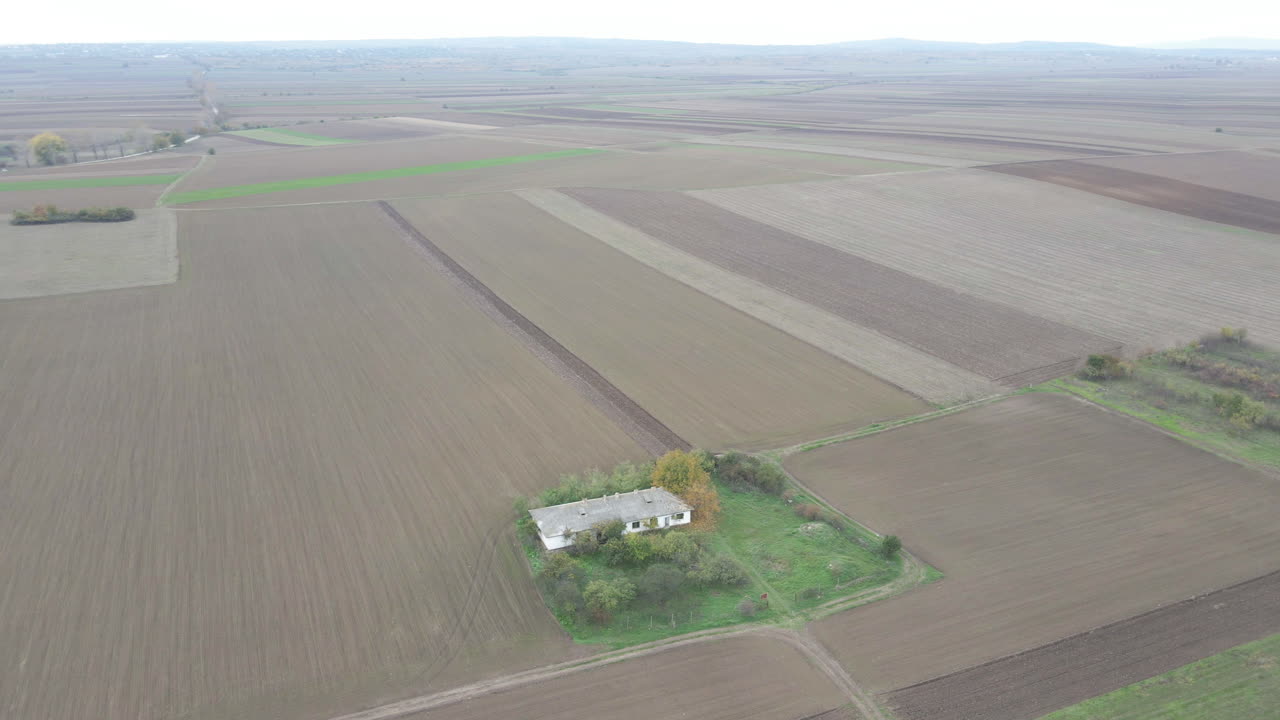 Drone aerial flyover white farmland house in a rural setting on misty morning