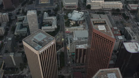 AERIAL:-Over-Skyscrapers-in-Downtown-Los-Angeles,-California-at-Sunset