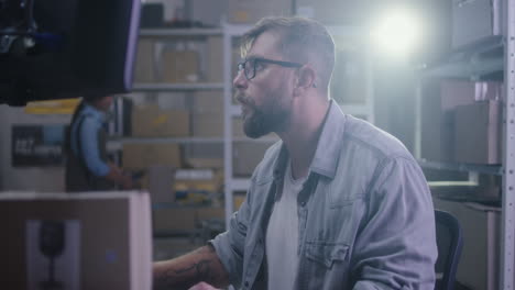 man working on computer in warehouse