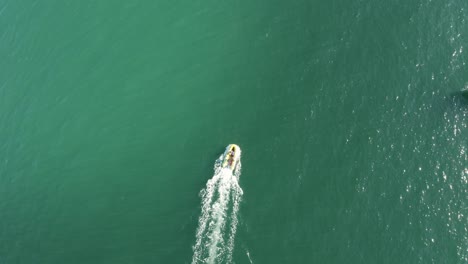 Wunderschöne-Drohnen-Filmaufnahme-Von-Oben,-Die-Einem-Schnellboot-über-Den-Brasilianischen-Ozean-Mit-Smaragdgrünem,-Klarem-Wasser-Folgt