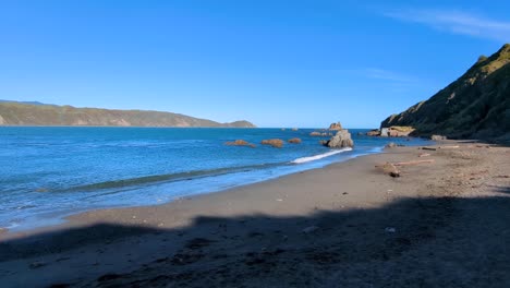 costa rocosa en la playa con agua azul del océano con vistas a la entrada al puerto de wellington en la capital de nueva zelanda aotearoa