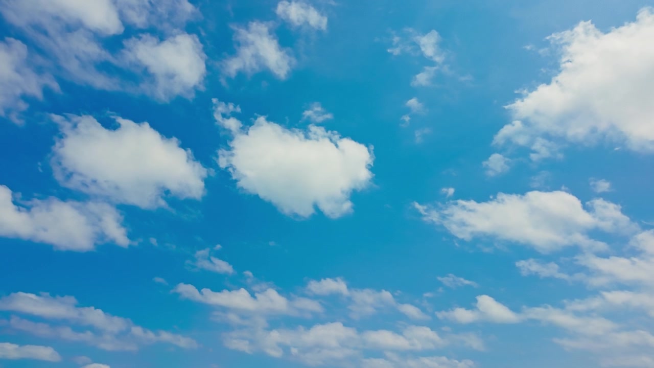 Nuvole bianche si muovono in un cielo blu sopra le Isole Okinawa, Giappone, con un'ampia scena di cielo tropicale. Inquadratura dal basso