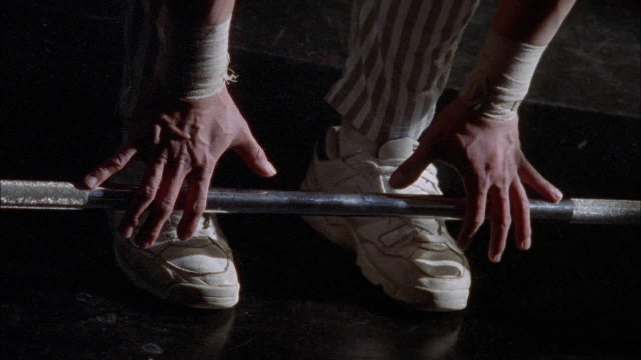 한 남자가 바벨 리프팅 운동을 한다