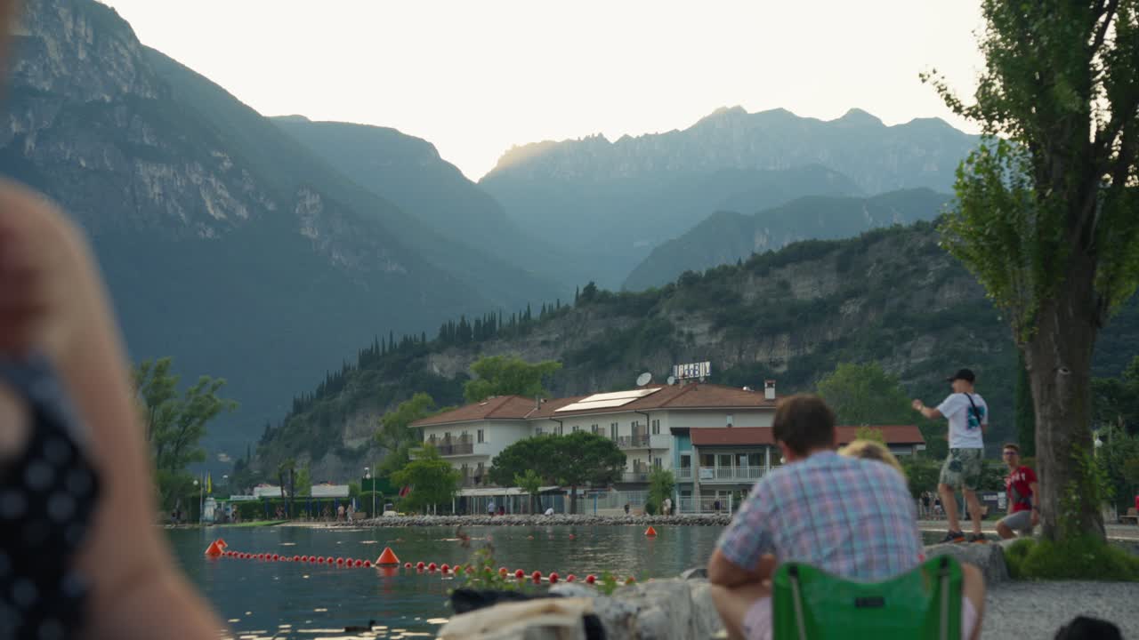 Scenic Lake View with Mountains and Lakeside Buildings at Sunset