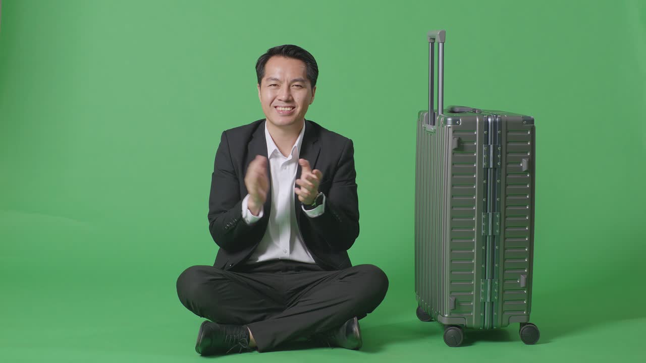 비즈니스맨이 녹색 스크린에 수과 함께 앉아 있습니다.