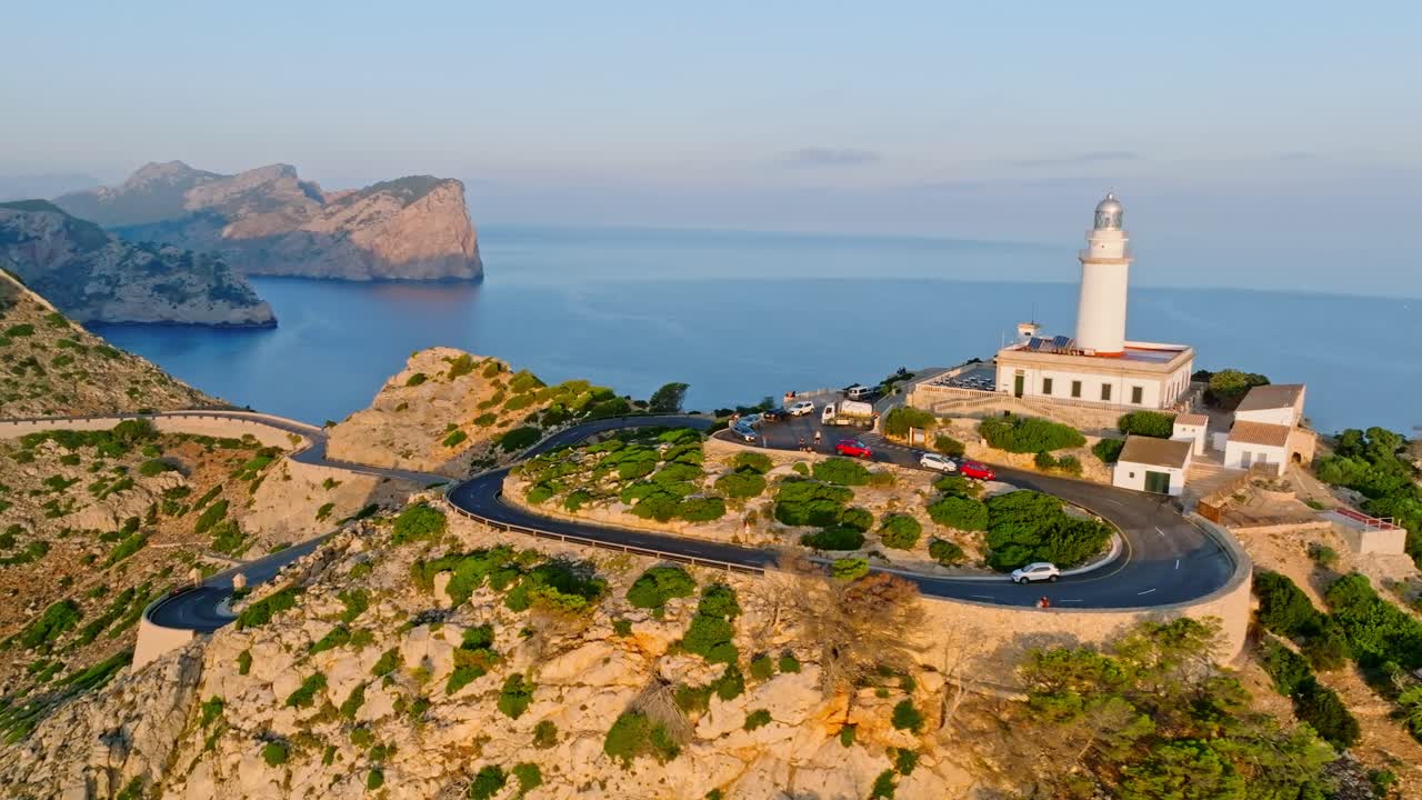 Golden hour glow illuminates Formentor lighthouse, Serra de Tramuntana Mallorca Spain and winding road