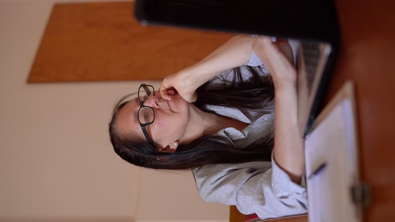 노트북 앞에서 일하는 한 여성이 경험하는 단조로움 - 수직 촬영