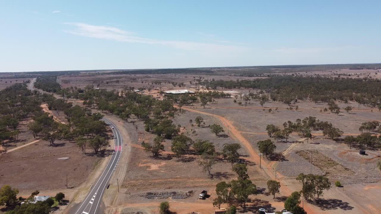 dron volando sobre una carretera de campo siguiendo un coche debajo