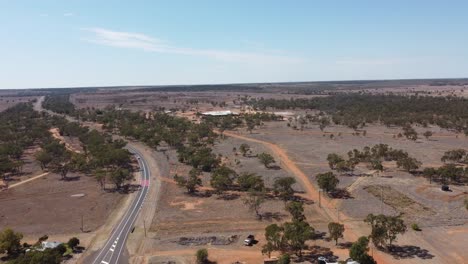 Drone-flying-over-a-country-road-following-a-car-below