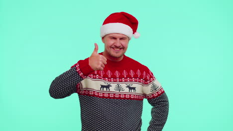 Funny-man-wears-red-New-Year-sweater-raises-thumbs-up-agrees-something-good,-like,-blue-background